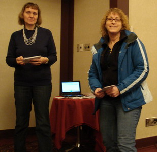 A smiling Jane Bissonnette receives her prize winnings from Miriam Gregory