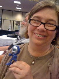 Lynn Dreyer holding her FOTD prize: a bendy robot clock